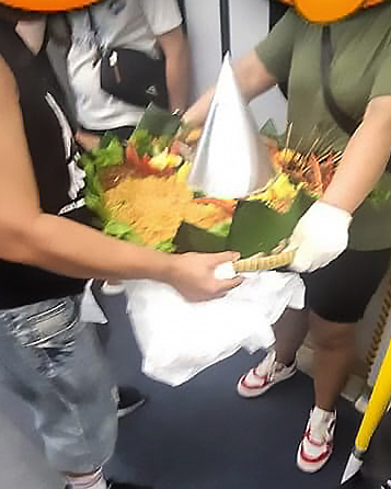 從該網民追蹤拍攝的相片看到，疑似外賣員共有兩位，兩人合力捧著一大盆食物。