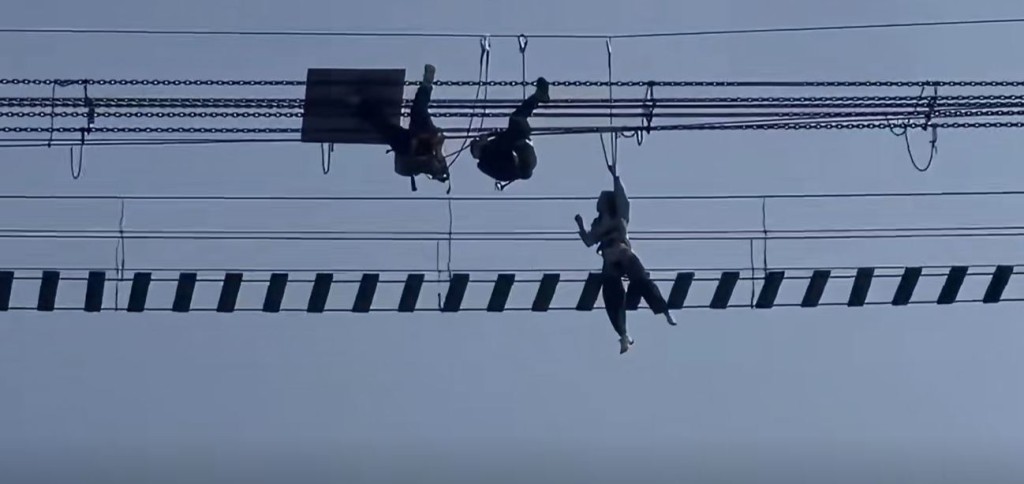 龙潭大峡谷景区有游客在玩网红铁索桥时，意外跌出，在半空吊吊揈。影片截图