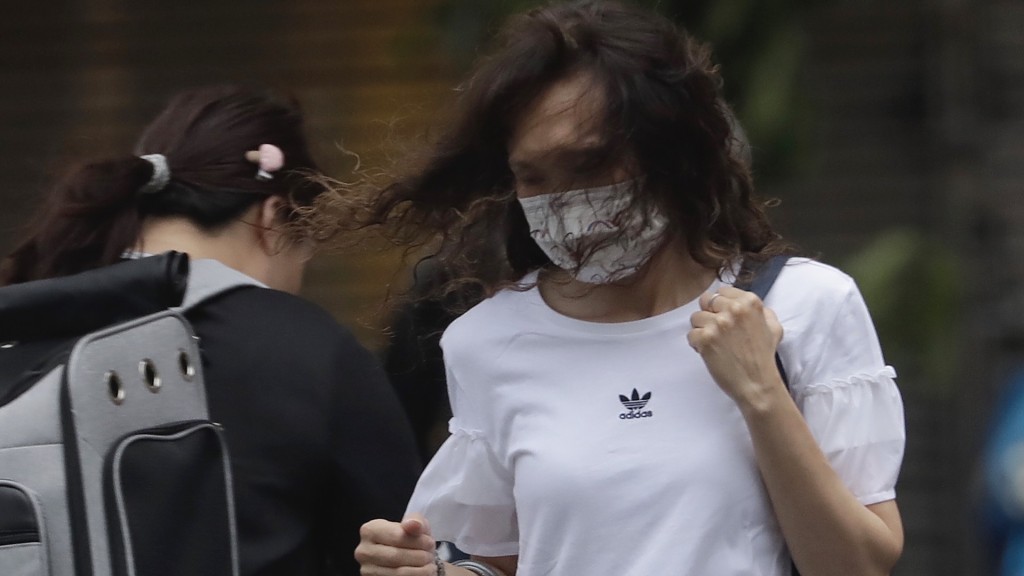台灣也受颱風瑪娃（Mawar）影響，台北一名路人被吹至頭髮亂舞。 美聯社