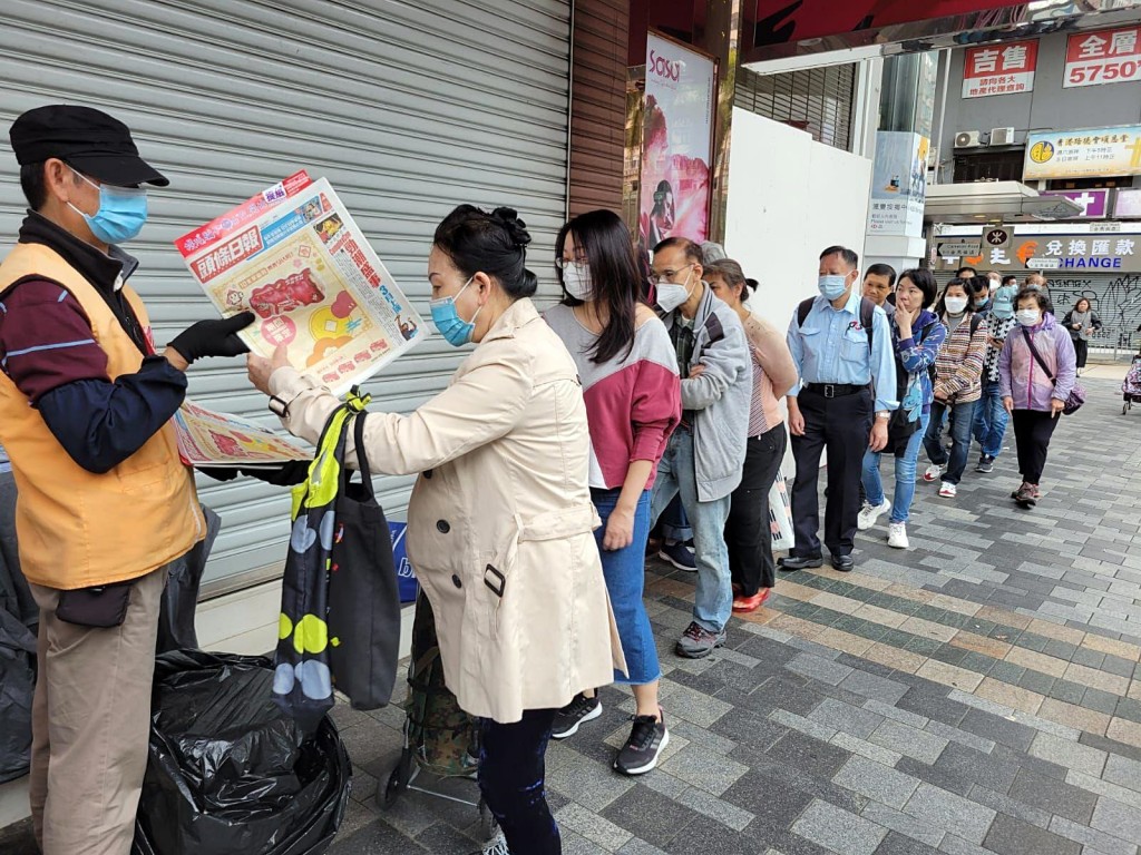 市民排队取阅附送《提纸》的免费报纸。
