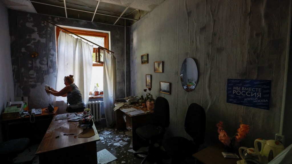 大学职员整理受损的办公室。 路透社