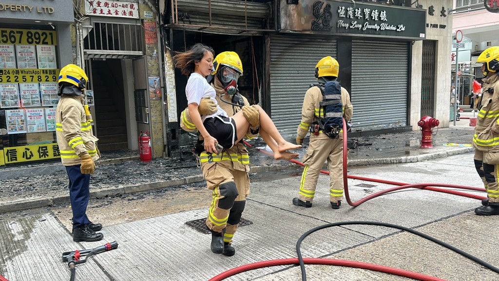 消防员抱起赤脚女子逃生。梁国峰摄