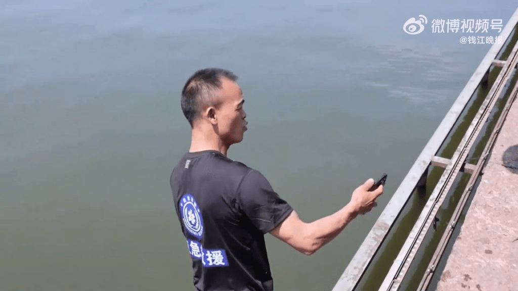 打撈員成功將跌落湖的手機撈起。