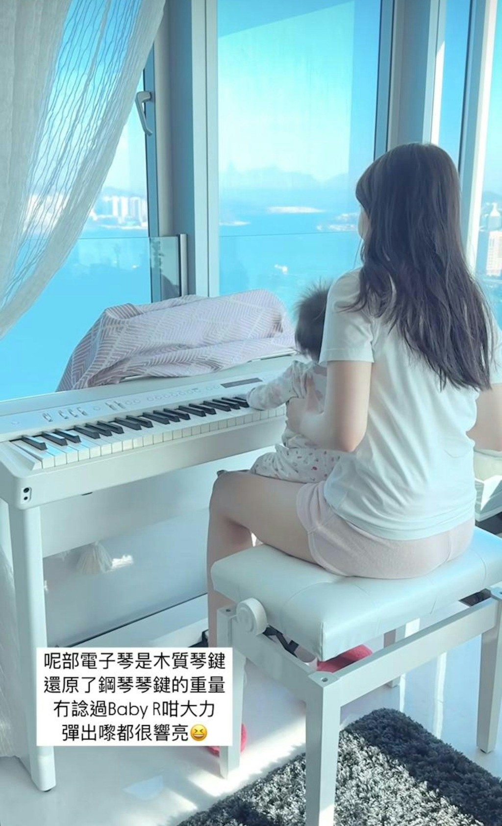 何依婷家居服的何依婷抱住女兒坐在鋼琴前，女兒伸出手仔觸碰琴鍵，兩母女溫馨互動。
