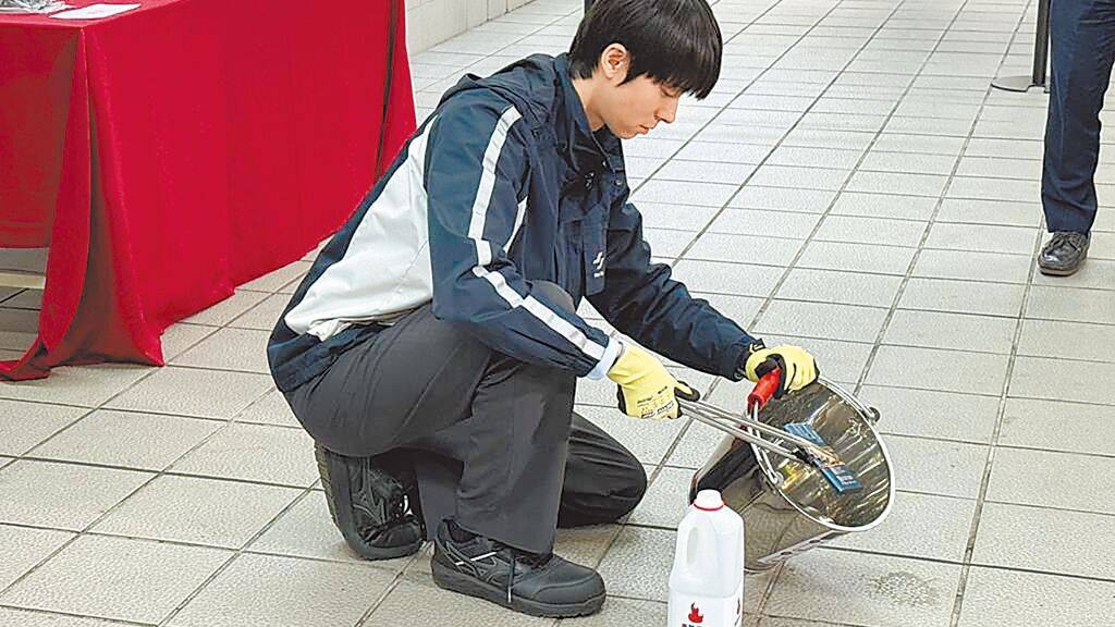 台捷站務人員示範處置自燃流動電源。 中時