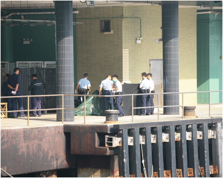 屍體撈上岸後警方用帆布遮蓋。楊偉亨攝