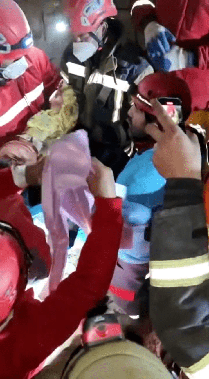 救难人员将被困婴儿抱出。