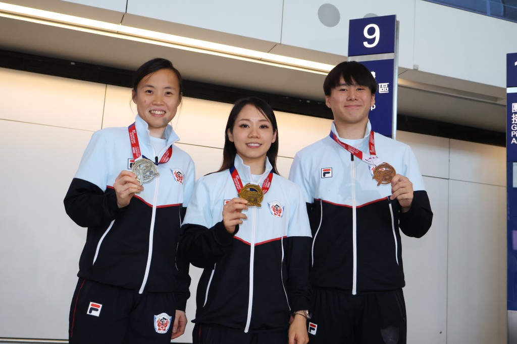 曾绮婷（左一）及刘慕裳（中）昨带著历史性的金牌返港，旁为年仅20岁夺首夺成人组铜牌的郑栩彬。