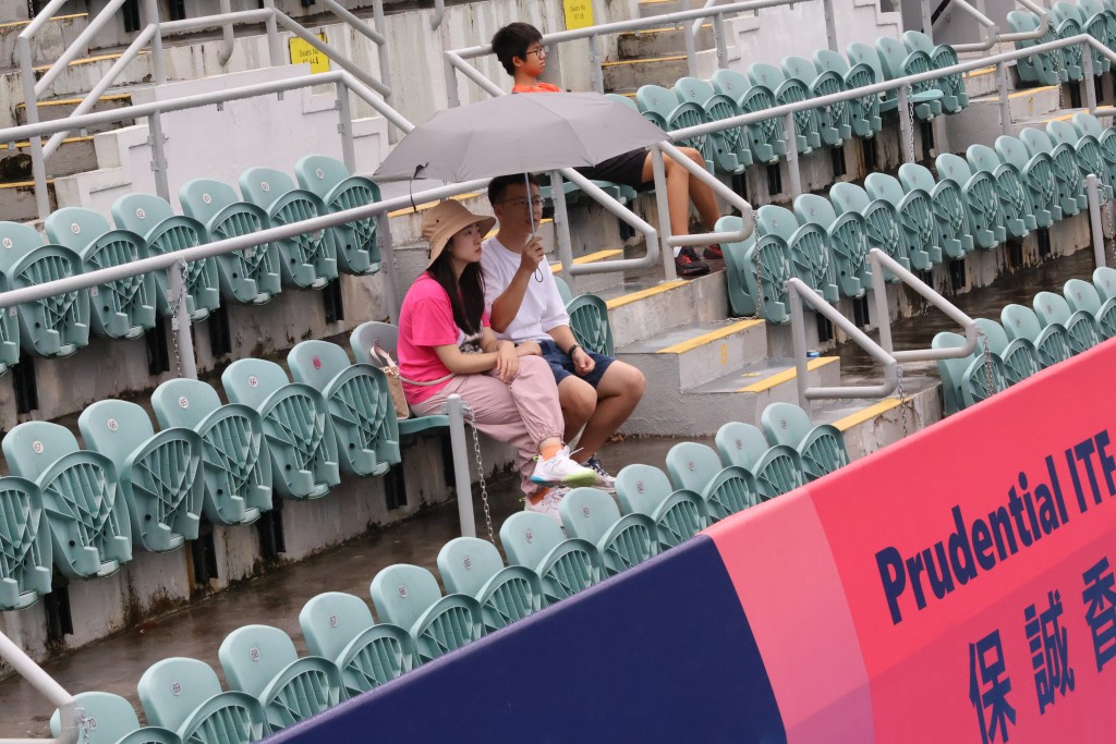观众撑著雨伞想看比赛，但雨还是下个不停。 徐嘉华摄