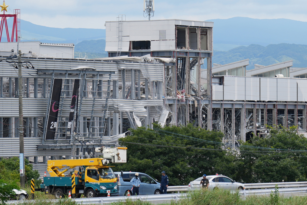 熊本县嘉岛町「永旺梦乐城熊本」因震后爆炸受损，重型机械在现场清理瓦砾。美联社