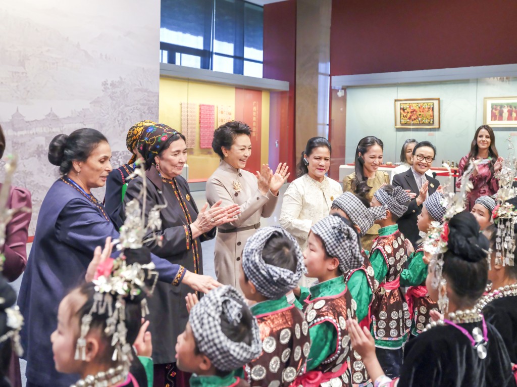彭丽媛同外方领导人夫人与来自贵州侗族大歌之乡的少年儿童交流。（新华社）