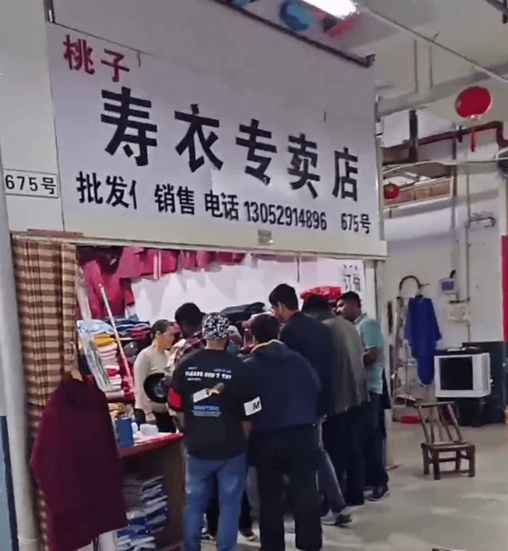 網上影片顯示,數名外國人擠滿在壽衣店門外。 網上影片顯示,數名外國人擠滿在壽衣店門外。