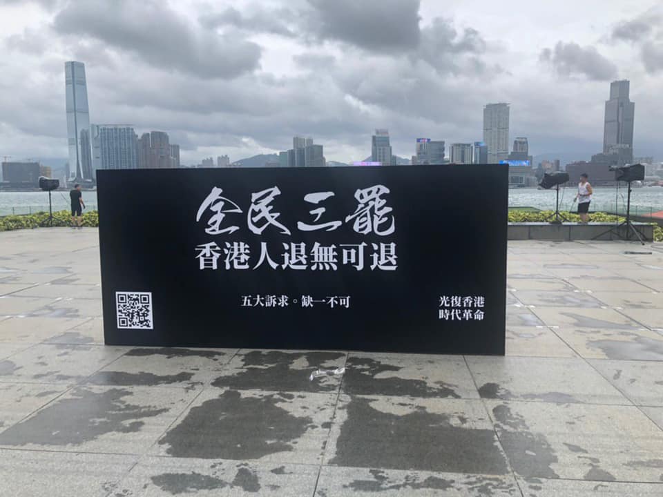 主辦單位在添馬公園放置「全民三罷 香港人退無可退」的黑色大台標語。 罷工FB圖