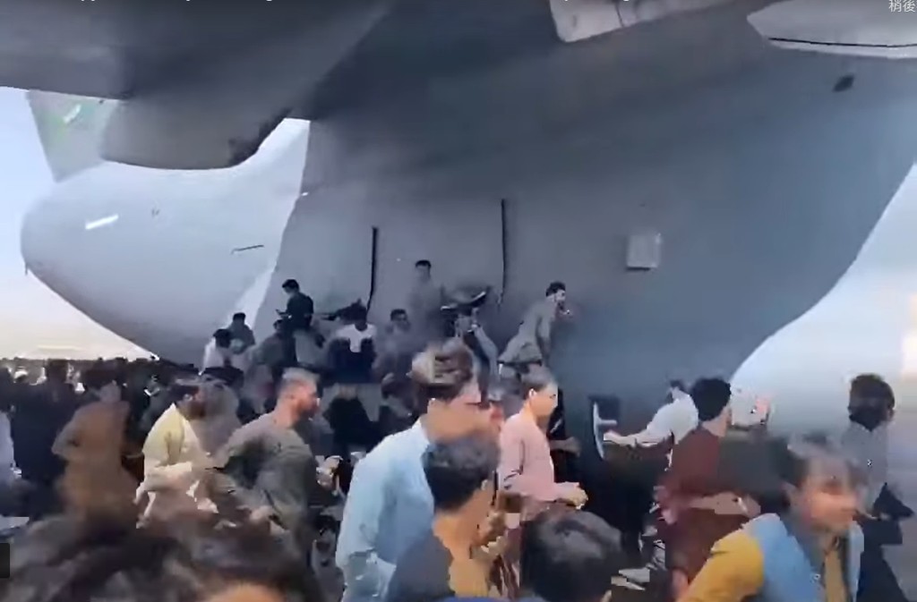 大批絕望的阿富汗人試圖攀附上美軍運輸機。網上圖片