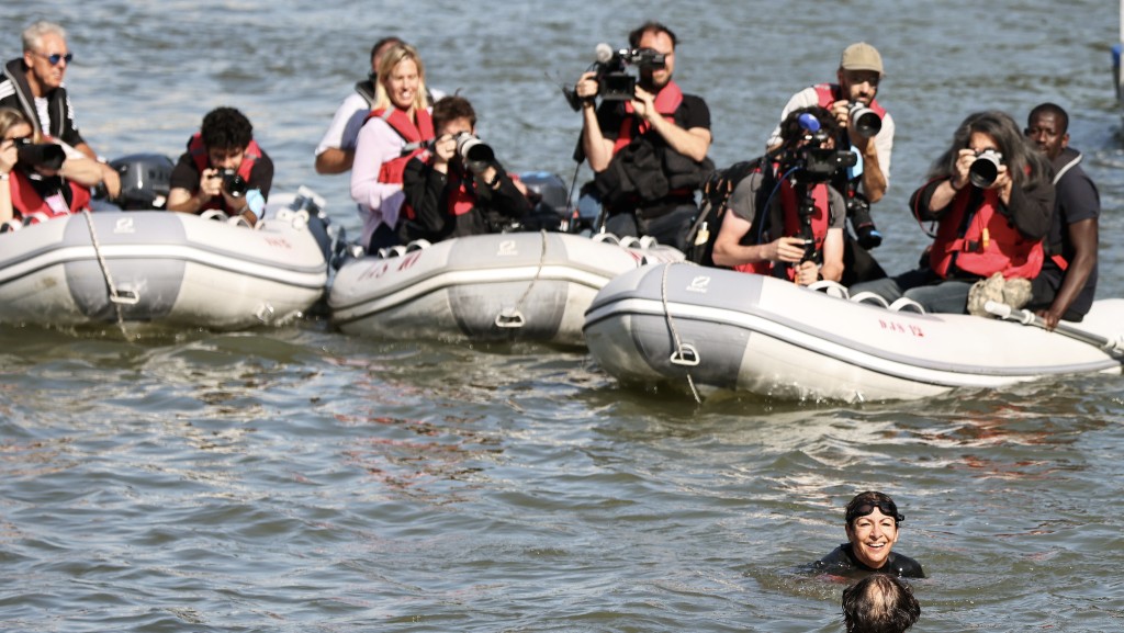 大批記者坐小艇拍攝伊達爾戈。  新華社