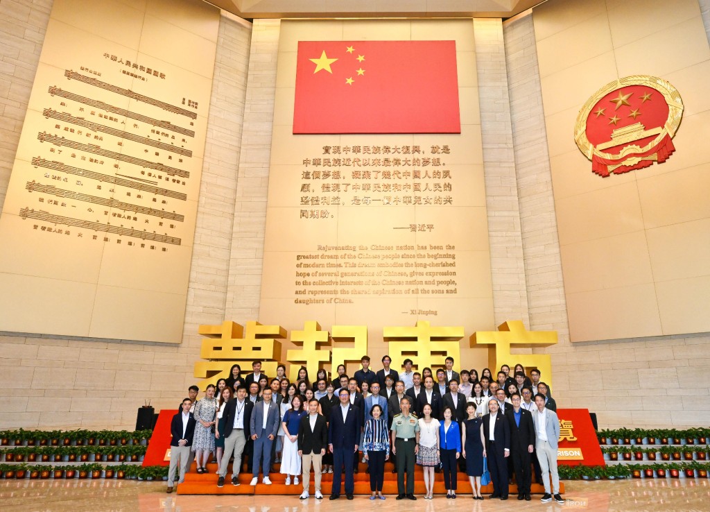 麥美娟（第一排左三）和團隊與中國人民解放軍駐香港部隊政治工作部副主任王志學大校（第一排左四）合照。政府新聞處