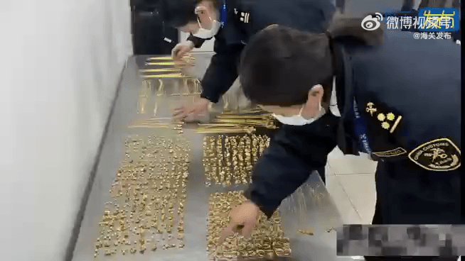 首都机场海关关员在点算男子身上搜获的金饰。