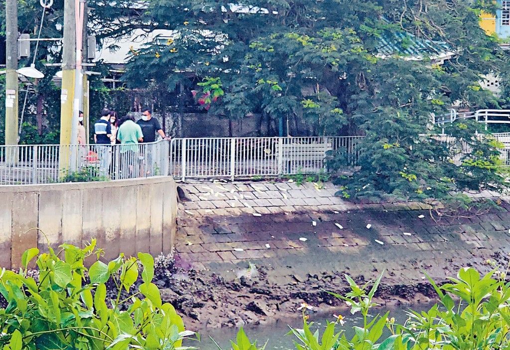 死者家人在河邊路祭，不斷向河中撒下溪錢。