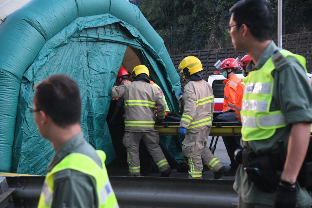 消防員搬運死者遺體。