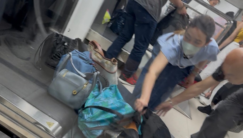 行李接受X光機檢查後,旅客紛紛上前領取。 行李接受X光機檢查後,旅客紛紛上前領取。