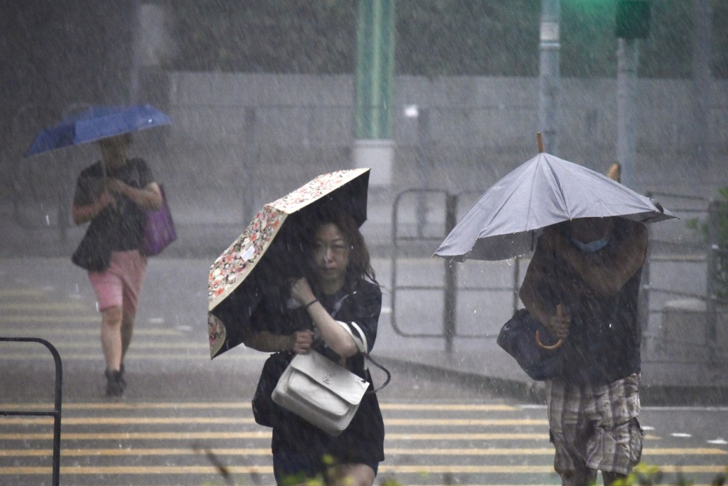 巿民冒雨上班,顯得十分狼狽。盧江球攝 巿民冒雨上班,顯得十分狼狽。盧江球攝