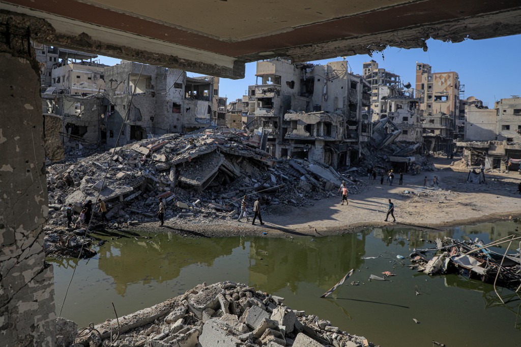加沙南部被毀建築物之間積有污水。（新華社）