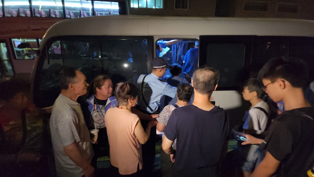 多名市民乘坐警方安排的小巴前往社區會堂。