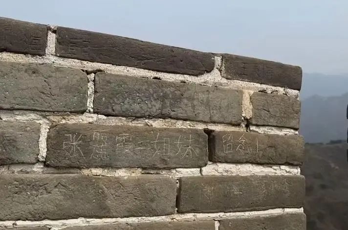 网上流传二人在长城刻字的情景。