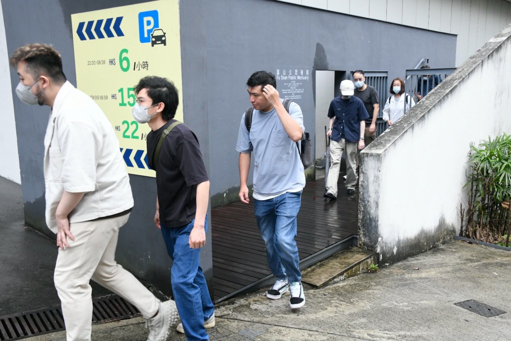 女死者多名親友到殮房認屍，黯然神傷。楊偉亨攝