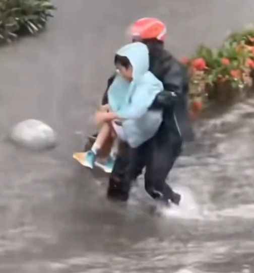 趙良金暴雨中抱起小孩。南方都市報