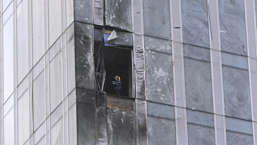 调查人员在被炸的在建大楼查看。美联社