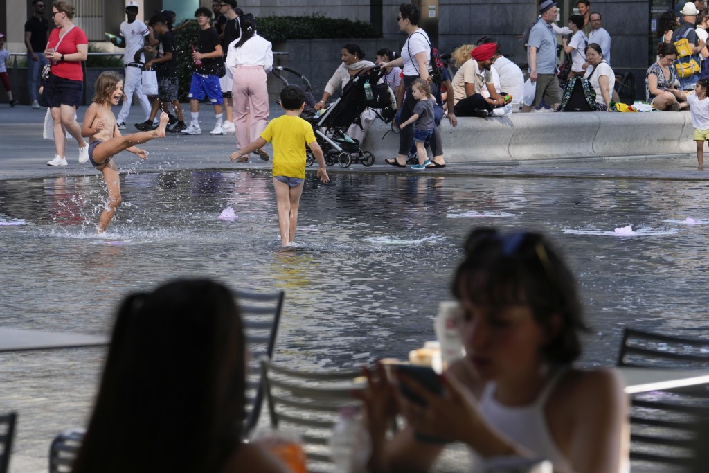 意大利米蘭小童走入噴泉玩水消暑。美聯社