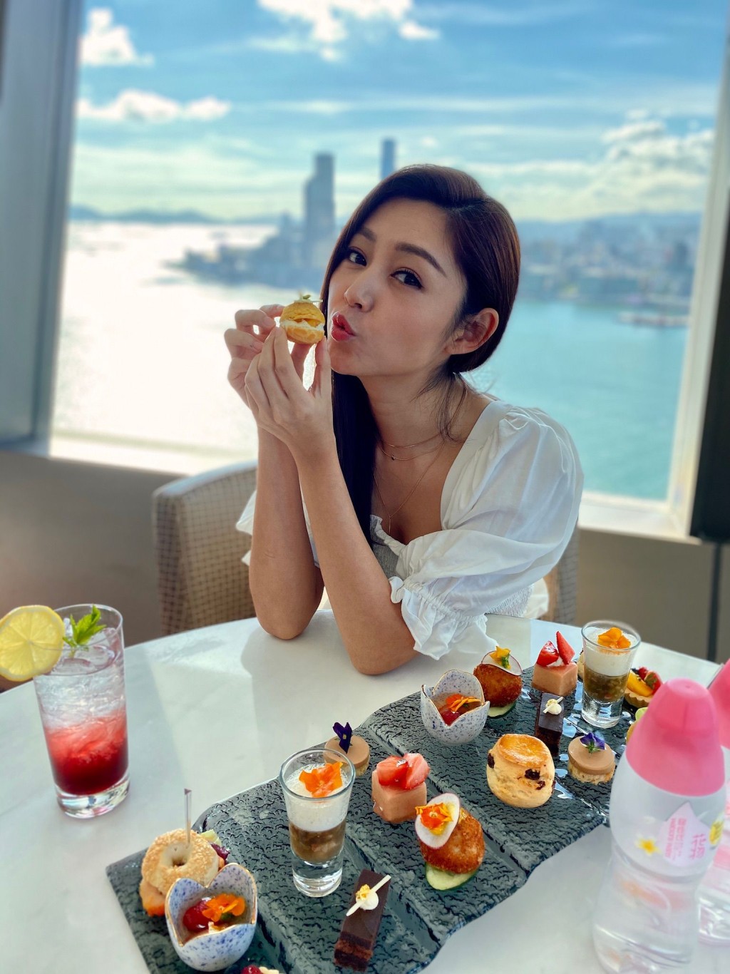Michelle於酒店一邊欣賞維港醉人景致一邊享用茶點。