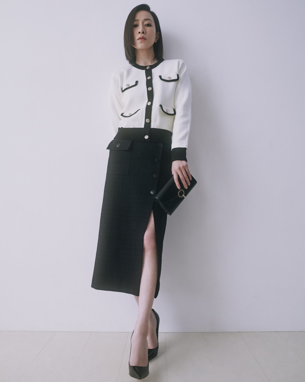 视后佘诗曼以黑色开衩Pencil Skirt，衬以黑白色上衣及黑色手袋，造型简洁优雅。