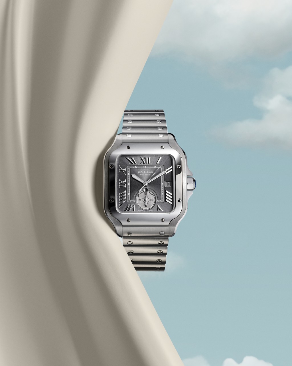 Santos de Cartier雙時區腕錶，大型款，白金或鉑金製，錶冠鑲嵌一顆藍色合成尖晶石，深灰色緞面錶盤，第二時區顯示盤附額外時針、晝夜顯示盤、夜光劍形指針。搭載自動上鏈機械機芯，具備雙時區功能。附精鋼錶鏈和深灰色鱷魚皮錶帶，配置QuickSwitch快拆鏈結系統及SmartLink快拆鏈節系統。（$72,000）