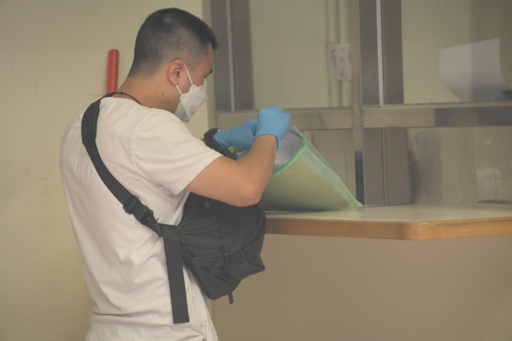 警員翻查傷者隨身物件。劉漢權攝