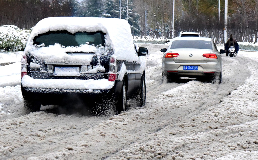 12月11日，车辆在雪中缓慢行进。 新华社