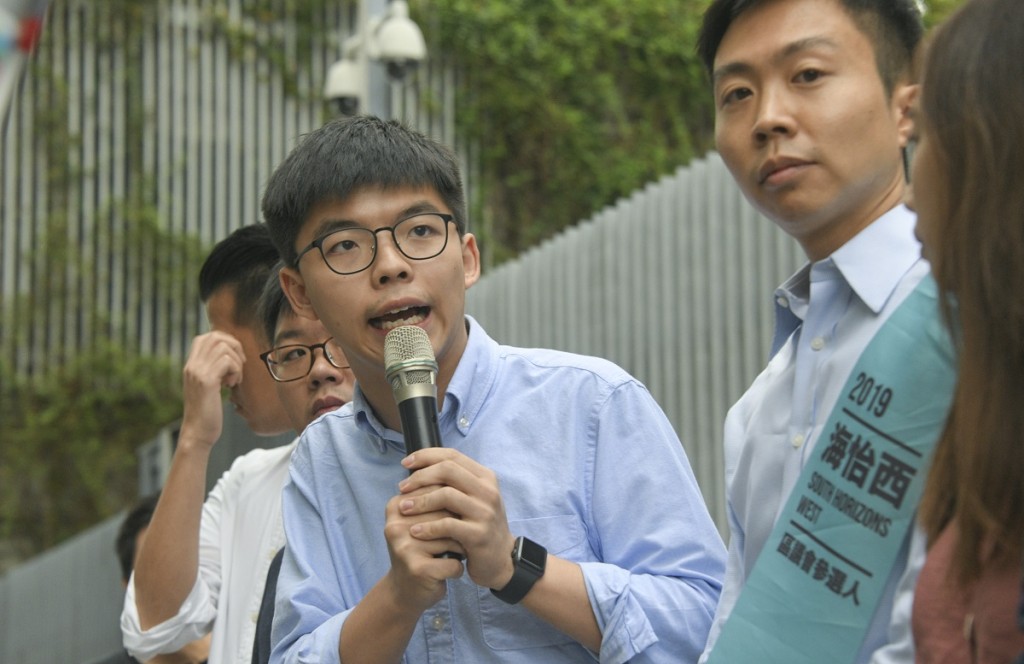 黃之鋒(持咪者)與海怡西候選人林浩波。