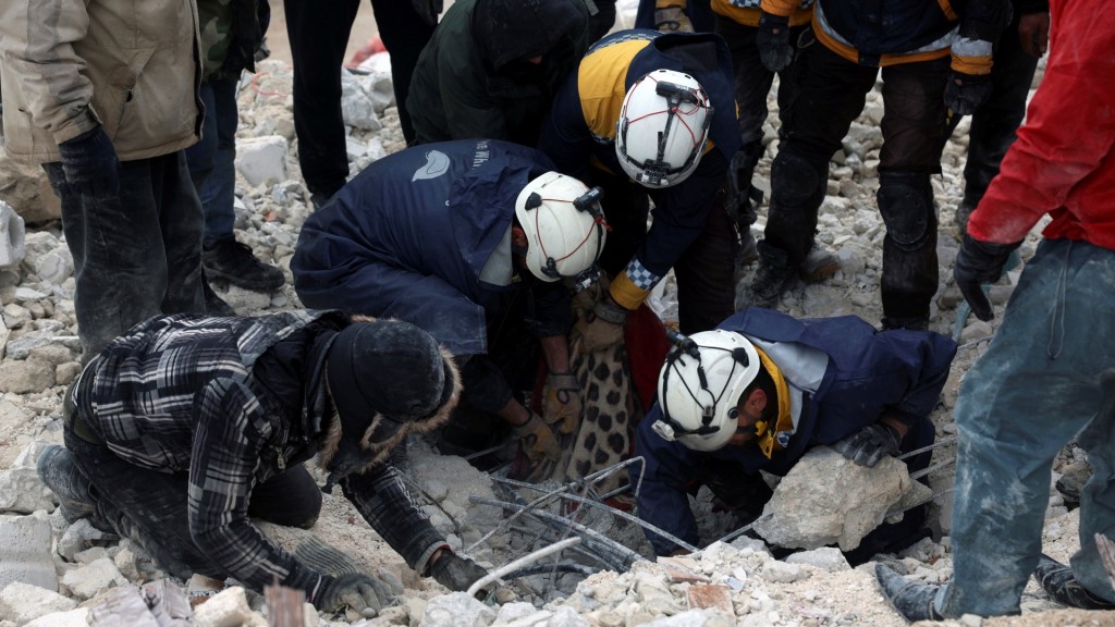 敍利亚国防军和幸存居民在伊德利卜（Idlib）Besnia村瓦砾堆中搜索。 美联社