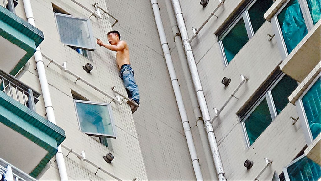 情緒激動的男子爬出露台危站水渠,消警人員游說他返回安全位置。