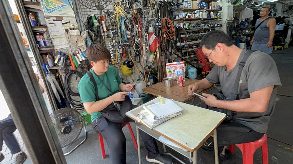 車房老闆娘與職員閒着沒事玩手機。楊偉亨攝 車房老闆娘與職員閒着沒事玩手機。楊偉亨攝