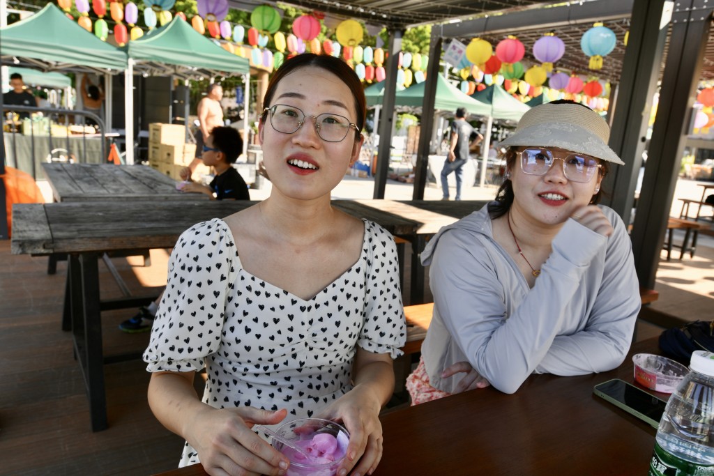 深圳遊客高小姐與王小姐結伴來港一日遊，受訪時兩人正在夜市內的涼亭吃着現場免費派發的雪糕。盧江球攝