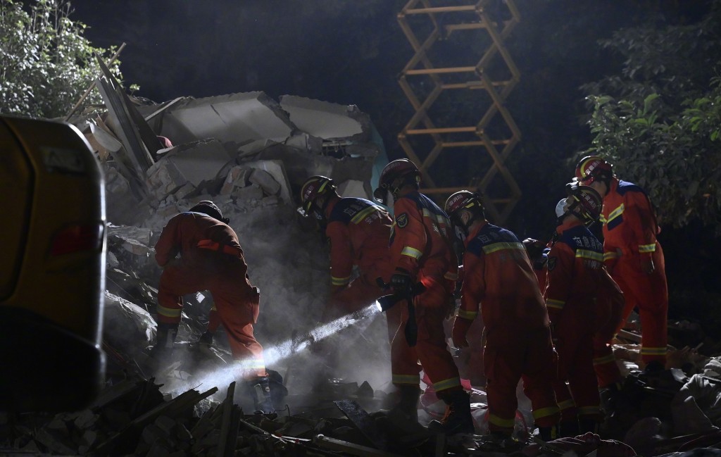 搜救人员连夜在塌楼现场搜索失踪者。
