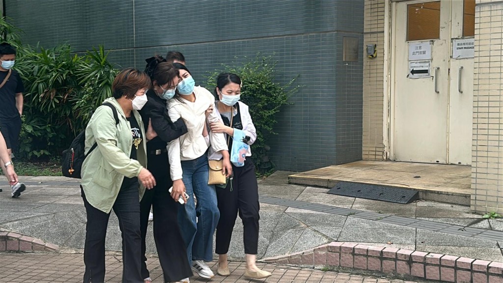 死者妻子（右二白衫）在親友攙扶下離開殮房。劉漢權攝