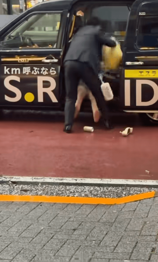 期间女子激烈反抗，男子强行把她像行李般强塞进车厢。