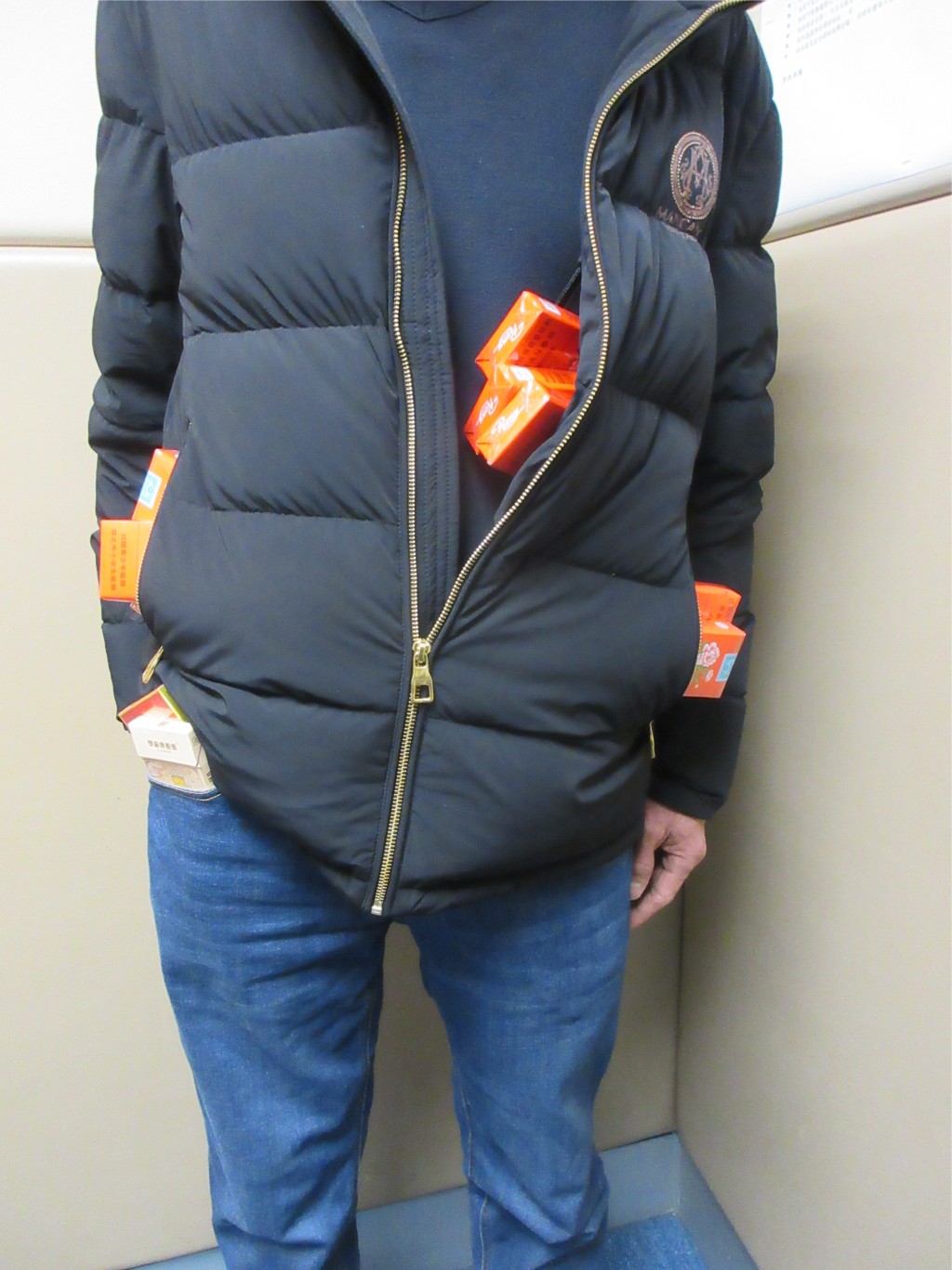 涉案男子在外套袋及褲袋內收藏未完稅香煙。海關圖片