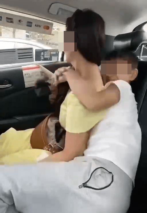 片中女网红与儿子在一辆出租车上，女网红穿著淡黄色露膊连衫裙，儿子则坐在其身边。