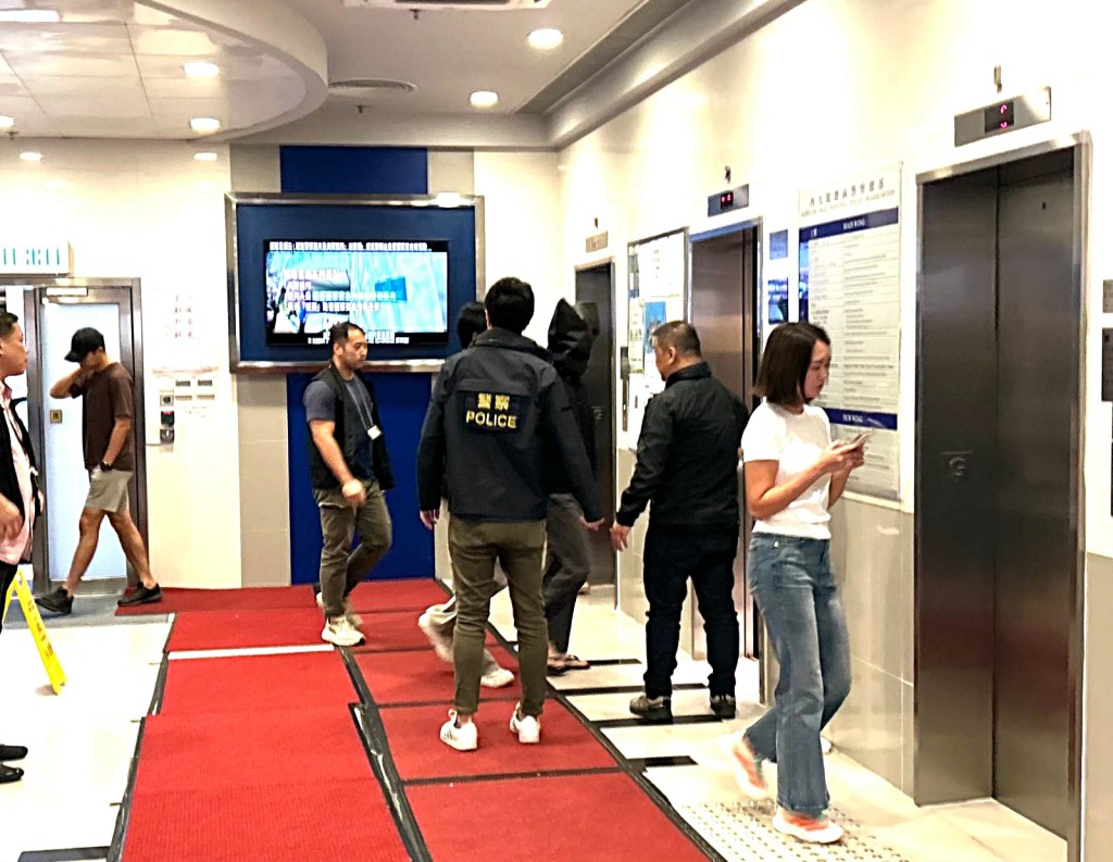 探員押解黑布蒙頭的「左口」。曾志恆攝 探員押解黑布蒙頭的「左口」。曾志恆攝