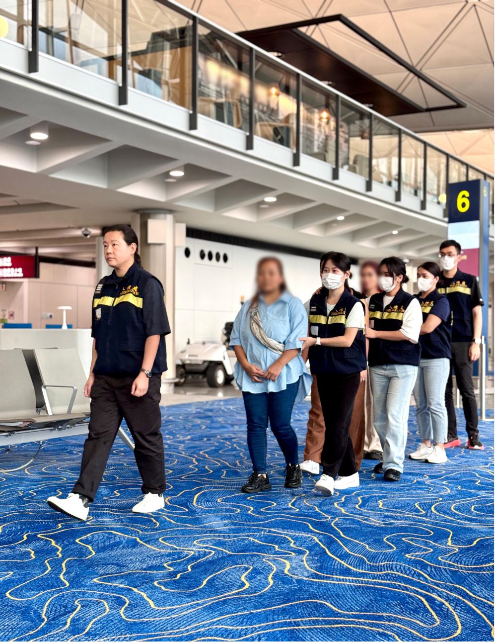 被遣返人士在入境處人員押送下離港。