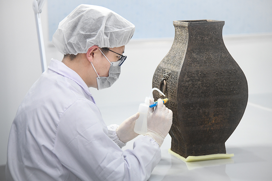 考古人员正为武王墩墓发现的青铜器做保护。